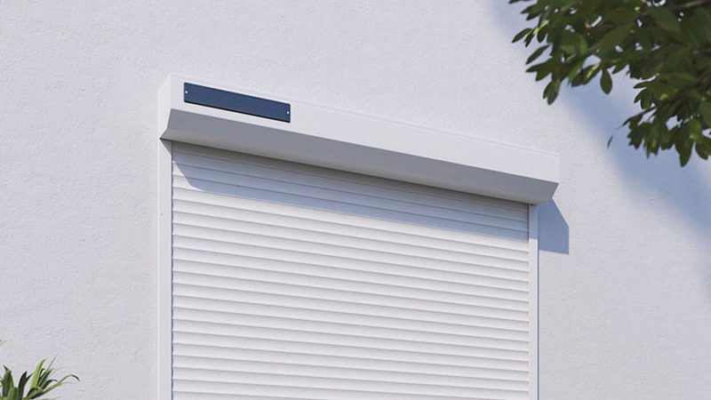 Volet roulant solaire fermé sur une façade blanche